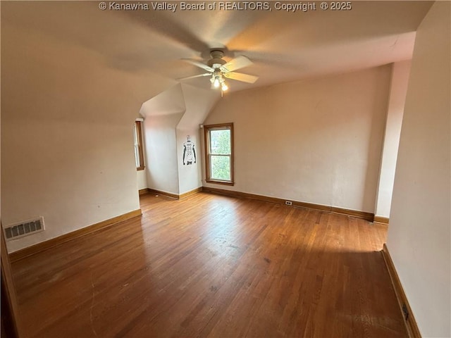 empty room featuring ceiling fan, wood-type flooring, and vaulted ceiling