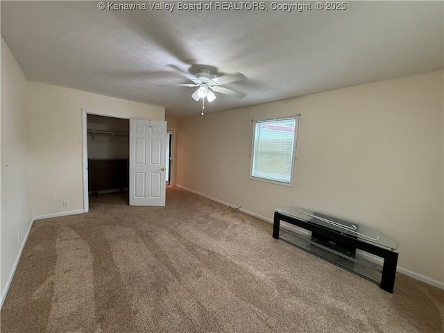 unfurnished bedroom with a spacious closet, carpet flooring, a textured ceiling, and a closet