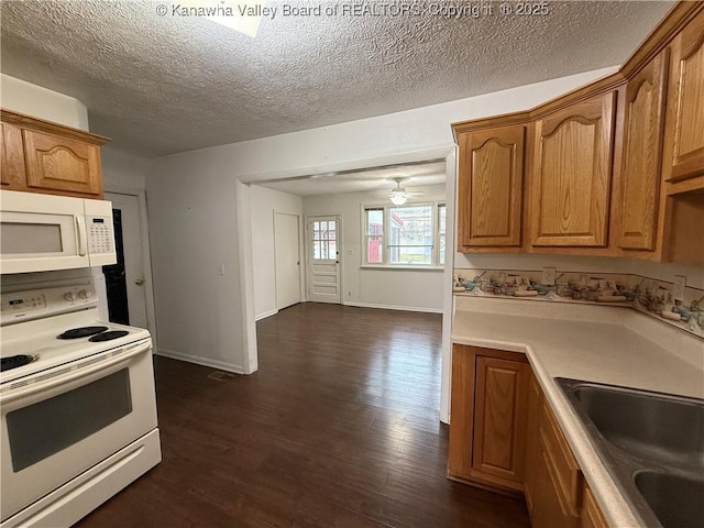 kitchen featuring sink, dark hardwood / wood-style flooring, white appliances, ceiling fan, and a textured ceiling