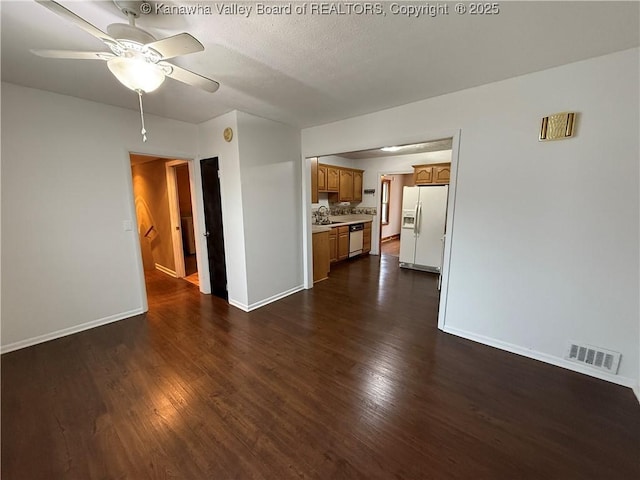 unfurnished living room featuring sink, dark hardwood / wood-style floors, and ceiling fan