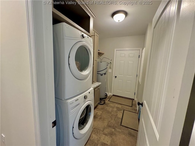 washroom featuring cabinets and stacked washer and dryer