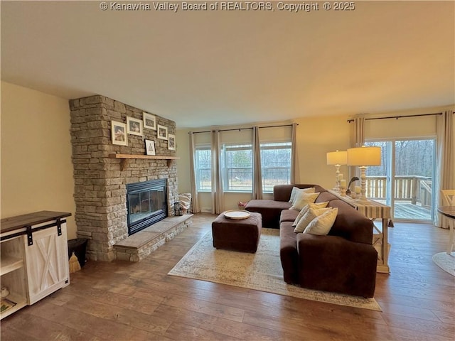 living room featuring hardwood / wood-style flooring and a stone fireplace