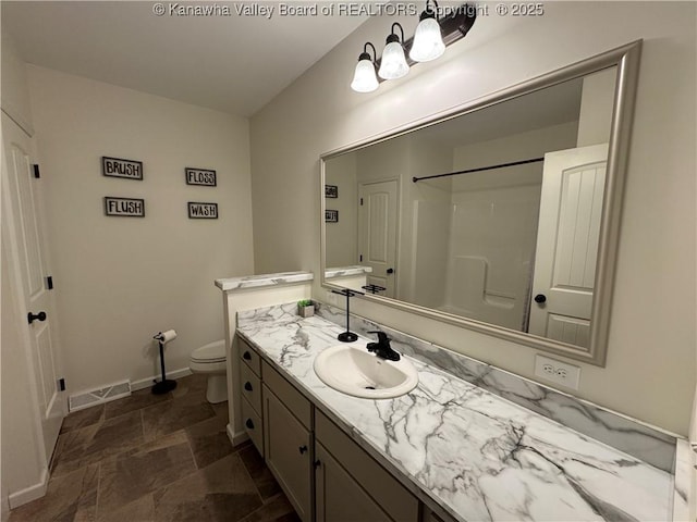 bathroom featuring vanity, toilet, and walk in shower