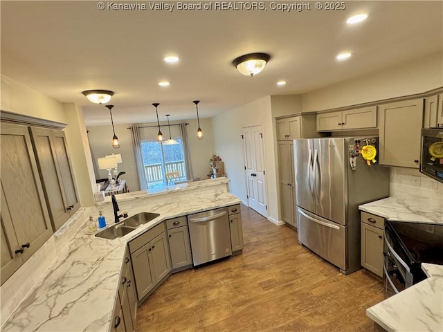 kitchen with sink, hardwood / wood-style floors, decorative light fixtures, gray cabinets, and appliances with stainless steel finishes