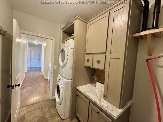 washroom with cabinets and stacked washer and clothes dryer