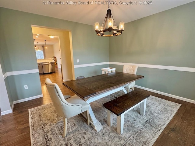 dining space with dark wood-type flooring and an inviting chandelier