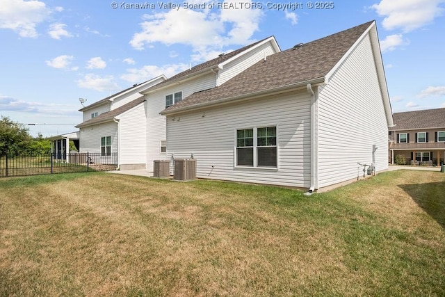 back of house featuring a lawn and central air condition unit