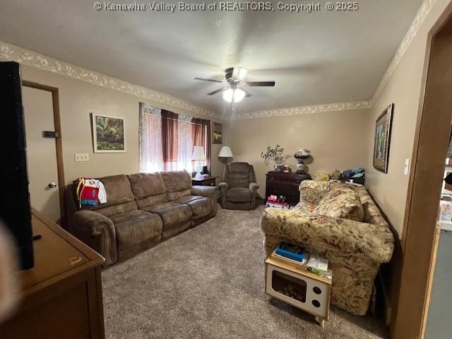 carpeted living room with ceiling fan and crown molding