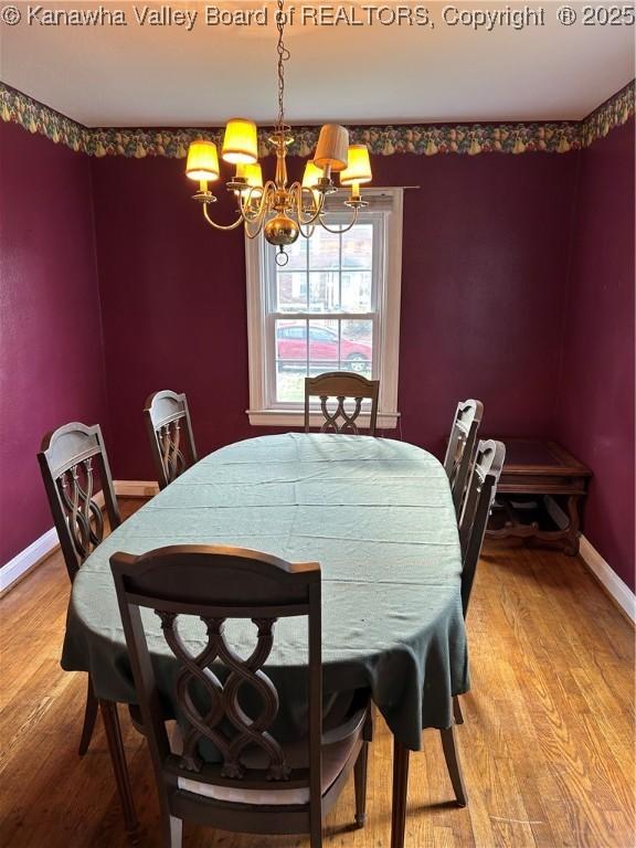 dining space with hardwood / wood-style flooring and an inviting chandelier