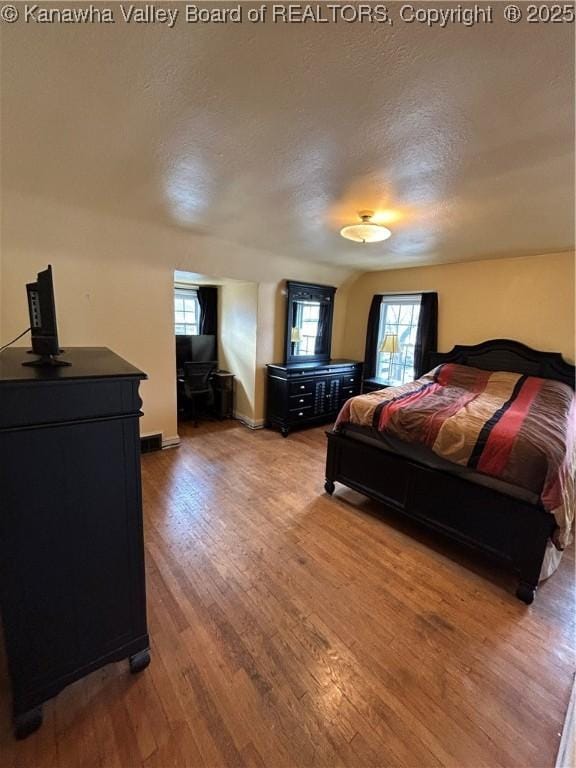 bedroom with hardwood / wood-style floors and a textured ceiling