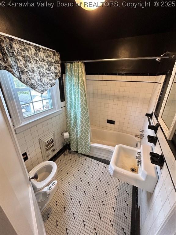 bathroom with tile patterned flooring, toilet, tile walls, and shower / bath combo with shower curtain