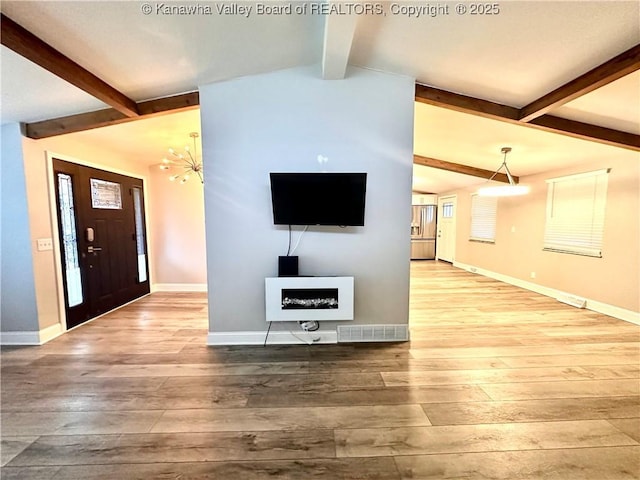 unfurnished living room with wood-type flooring, vaulted ceiling with beams, and an inviting chandelier