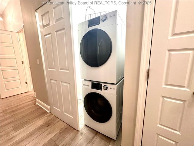 washroom featuring stacked washing maching and dryer and light hardwood / wood-style floors