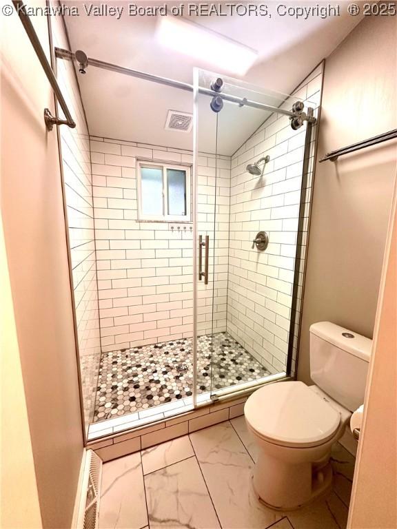 bathroom featuring toilet and walk in shower