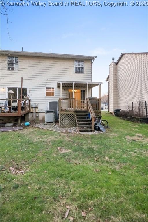 rear view of property with a lawn, cooling unit, and a wooden deck