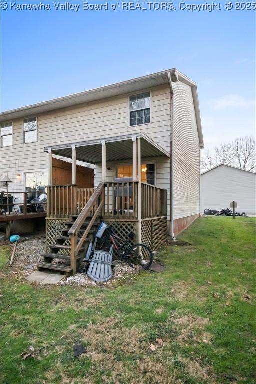 back of property with a yard and a deck