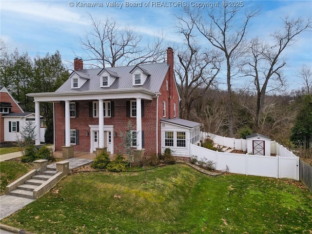 view of front of home with a shed and a front lawn