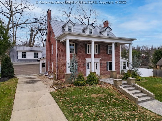 view of front facade with a garage, an outbuilding, and a front yard