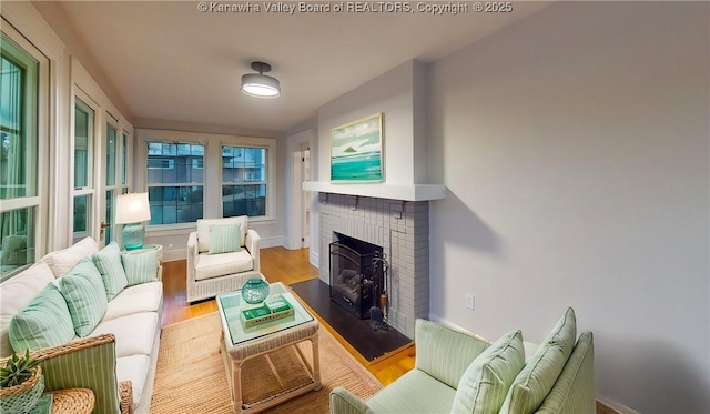 living room with light wood-type flooring and a brick fireplace