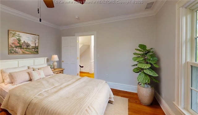 bedroom with crown molding, ceiling fan, and hardwood / wood-style flooring