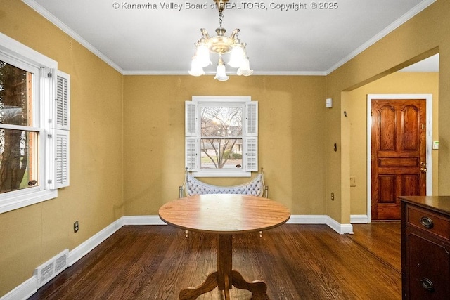 dining room featuring hardwood / wood-style flooring, an inviting chandelier, and crown molding