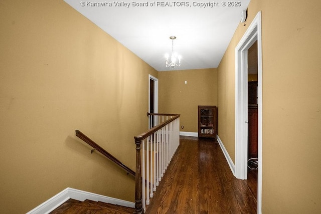 hall with dark hardwood / wood-style floors and a chandelier