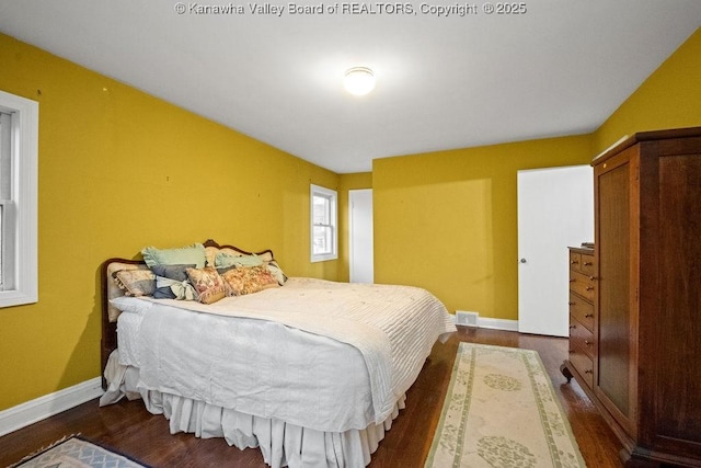 bedroom with dark hardwood / wood-style floors