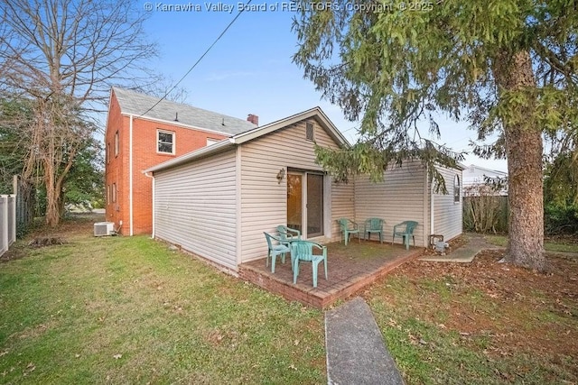 back of house with central AC unit, a patio area, and a lawn