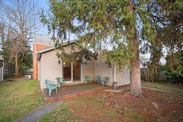 rear view of house featuring a lawn and a patio area