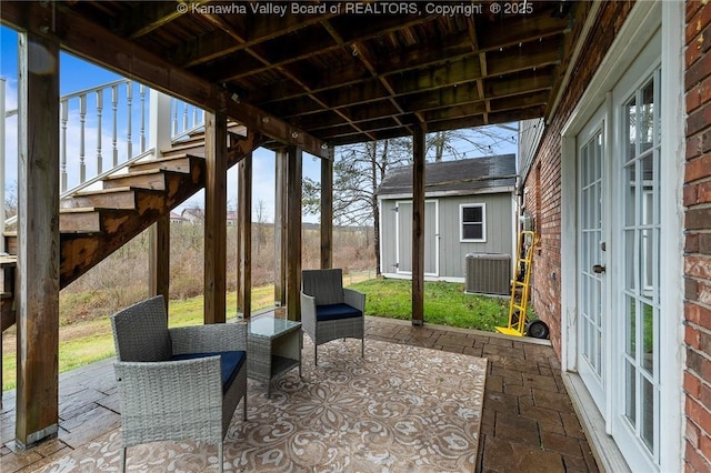 view of patio with central AC and a storage unit