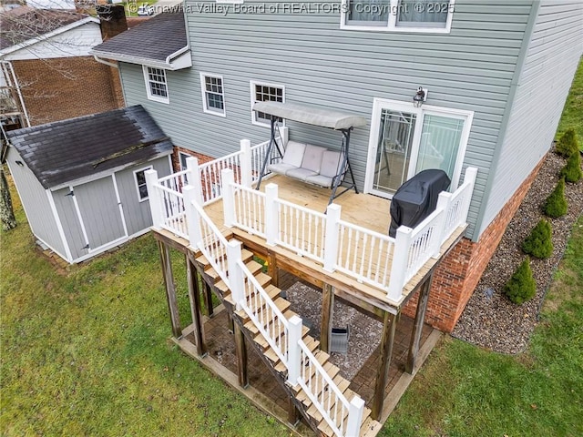 wooden deck with a storage unit and a lawn