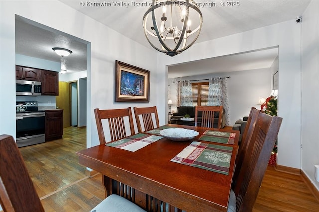 dining space with dark hardwood / wood-style flooring and a chandelier