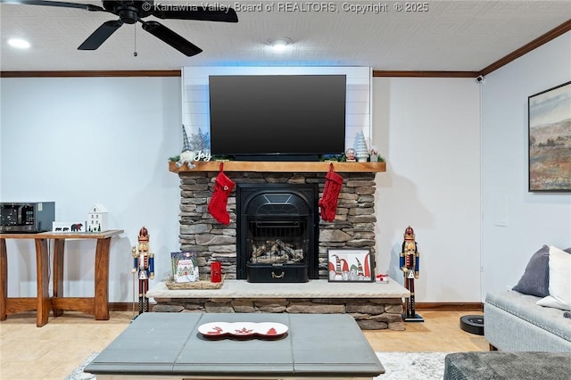 living room with a wood stove, crown molding, and ceiling fan