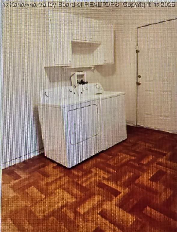 laundry room with dark parquet flooring and washer and clothes dryer