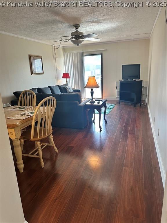 living room featuring a textured ceiling, dark hardwood / wood-style floors, and ornamental molding