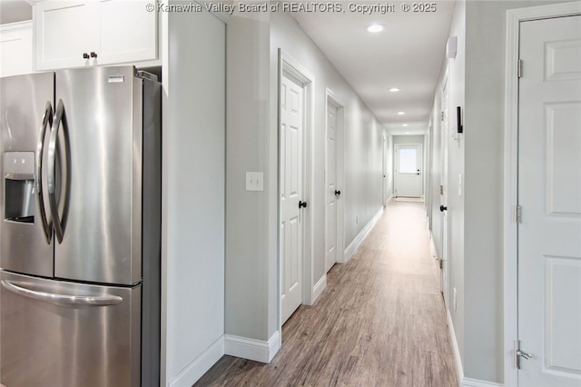 kitchen featuring light hardwood / wood-style floors, white cabinetry, and stainless steel refrigerator with ice dispenser