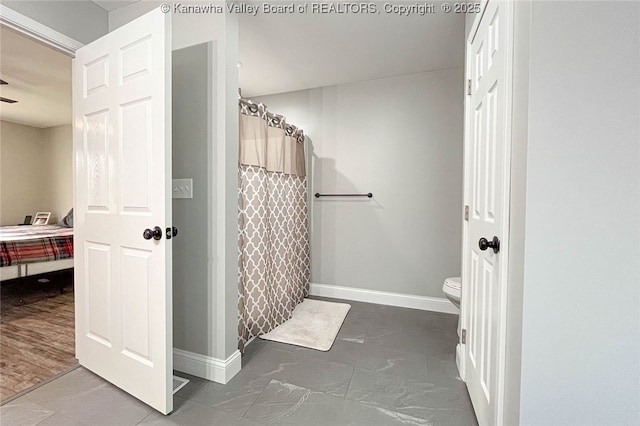 bathroom featuring a shower with shower curtain and toilet