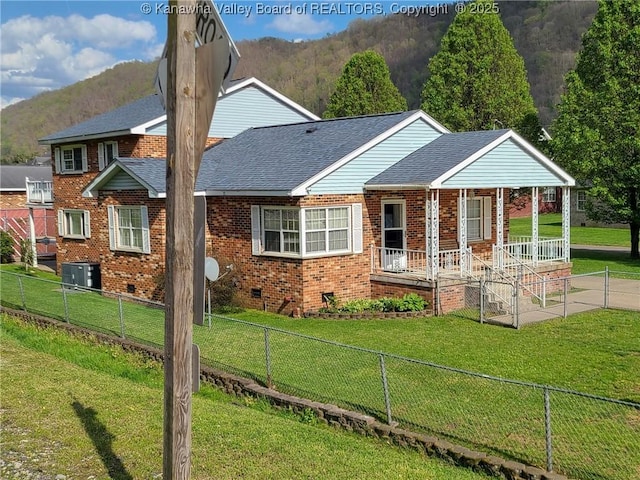 view of front of house featuring a mountain view, a front lawn, and covered porch