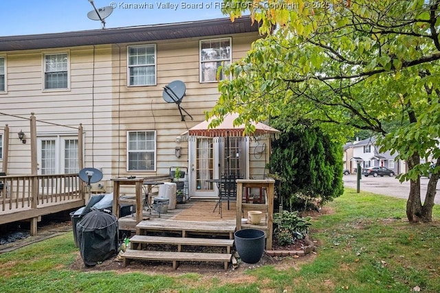 back of house featuring a yard and a wooden deck