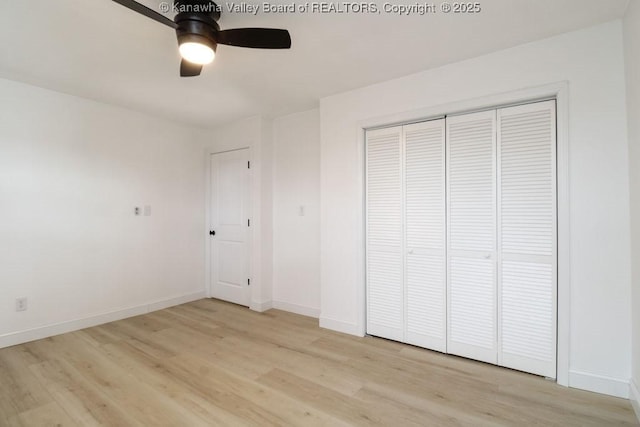 unfurnished bedroom with ceiling fan, light wood-type flooring, and a closet