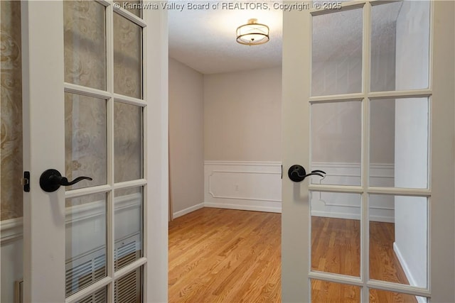 spacious closet with french doors and hardwood / wood-style flooring