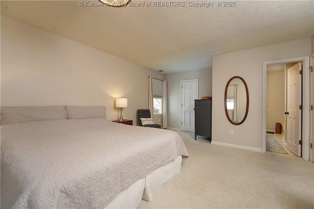 bedroom with light carpet and a textured ceiling