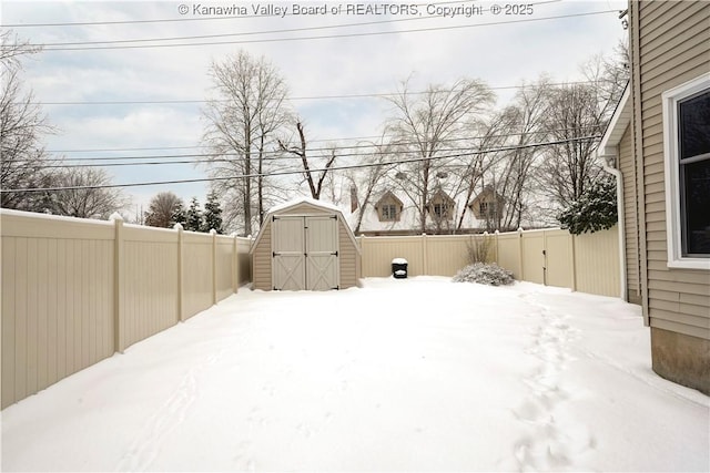 yard covered in snow featuring a storage unit