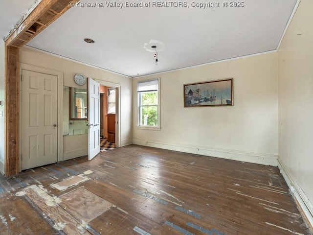 unfurnished bedroom featuring dark wood-type flooring and ornamental molding