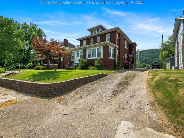 view of front facade with cooling unit and a front lawn