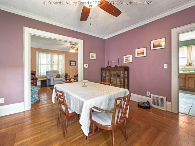 dining space featuring crown molding, sink, ceiling fan, and hardwood / wood-style floors