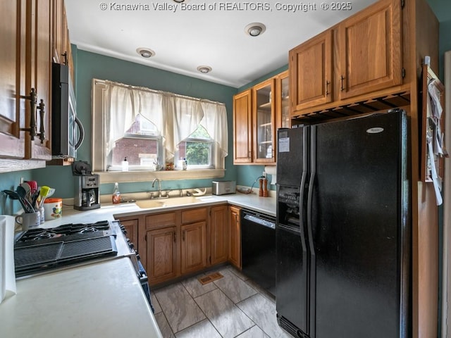 kitchen with light tile patterned floors, sink, and black appliances