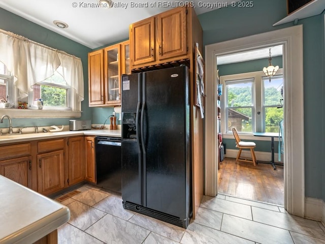 kitchen with a chandelier, hanging light fixtures, light tile patterned floors, and black appliances