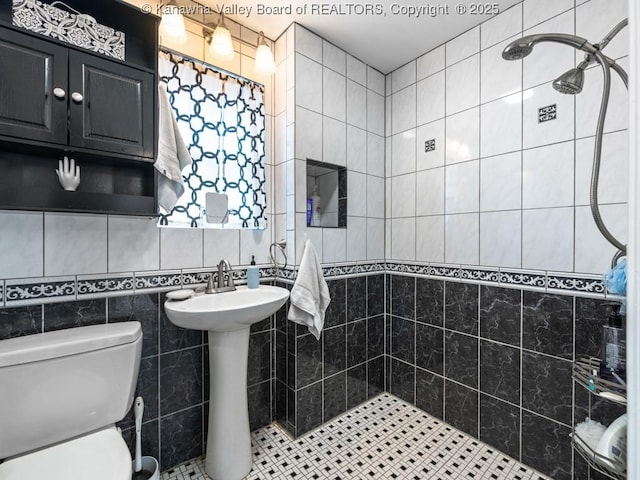 bathroom with sink, tile walls, tile patterned flooring, toilet, and curtained shower