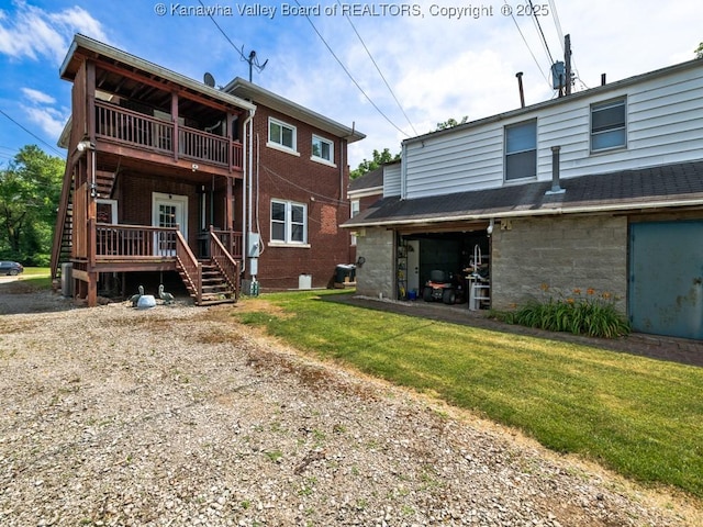 back of property with a lawn and a balcony